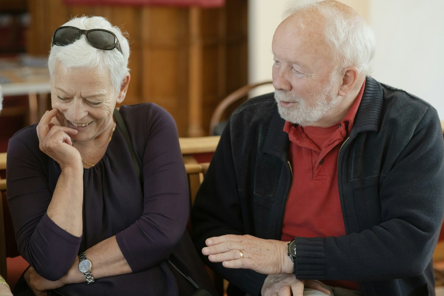 An older couple laughing together at a cafe table