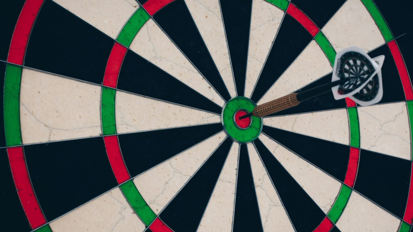 A dart stuck in the bullseye of a dartboard