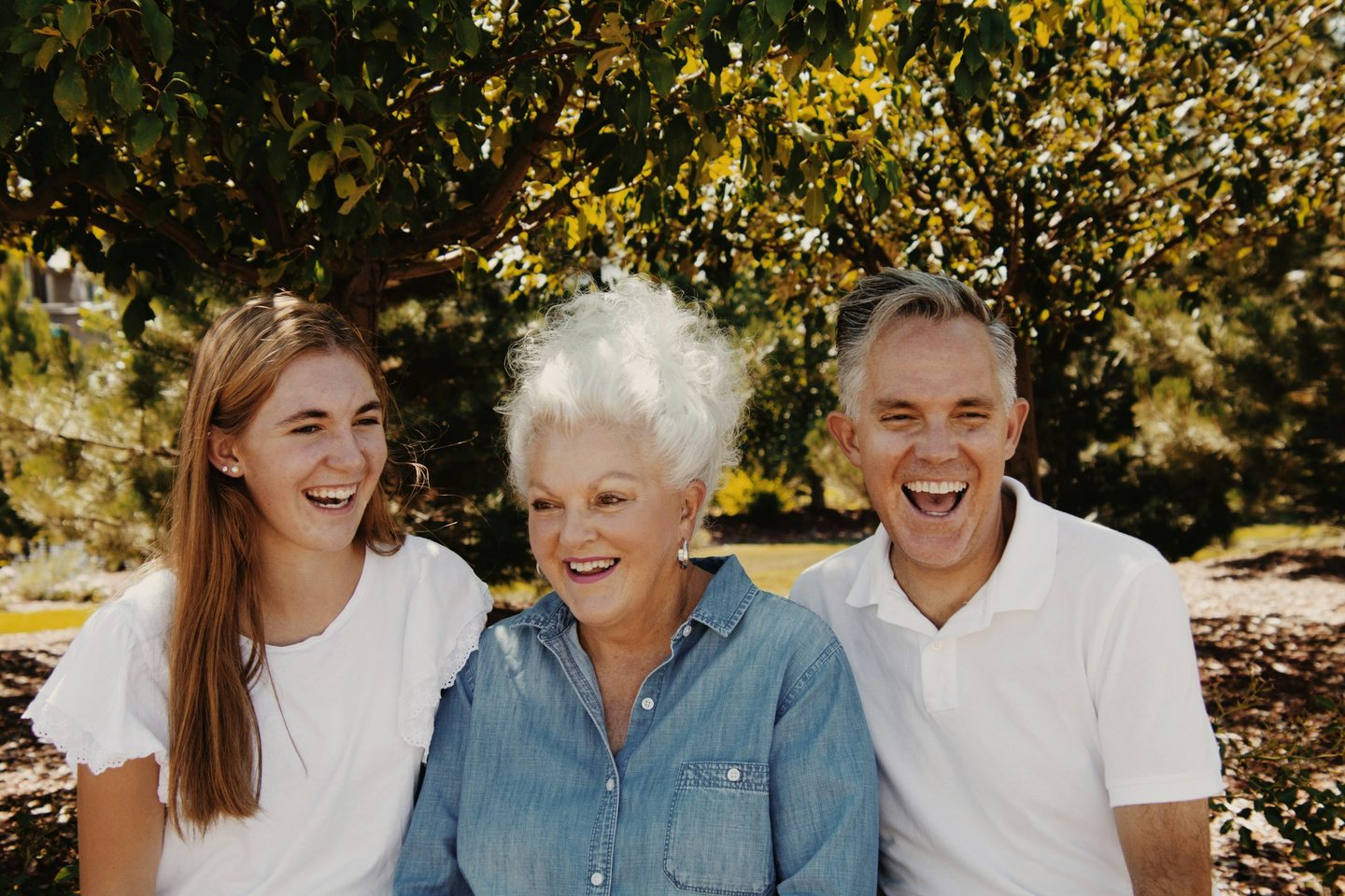 A family of three laughing together outdoors
