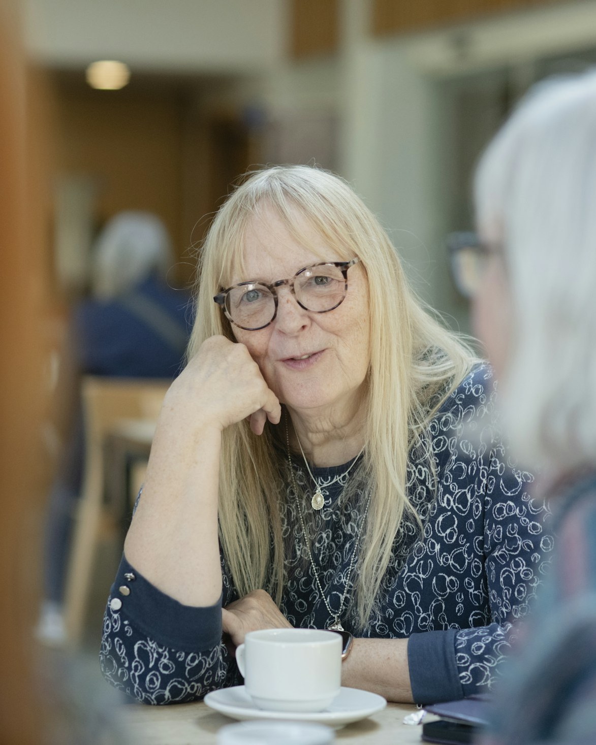 An older woman leaning in to listen during a conversation at home