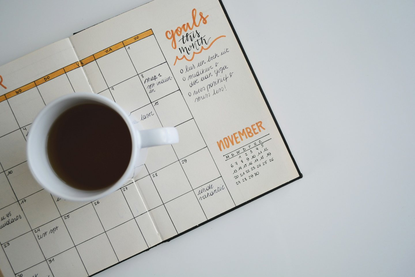 A cup of coffee on an open monthly planner