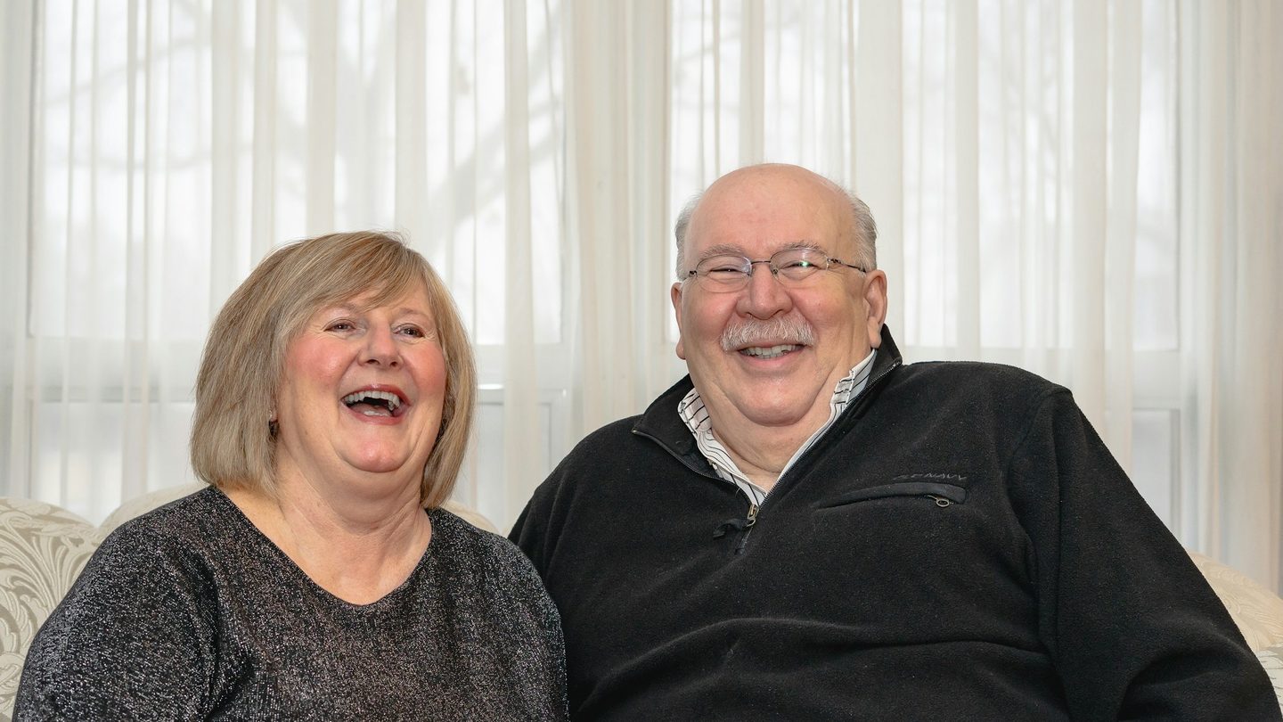 An older couple laughing together at home