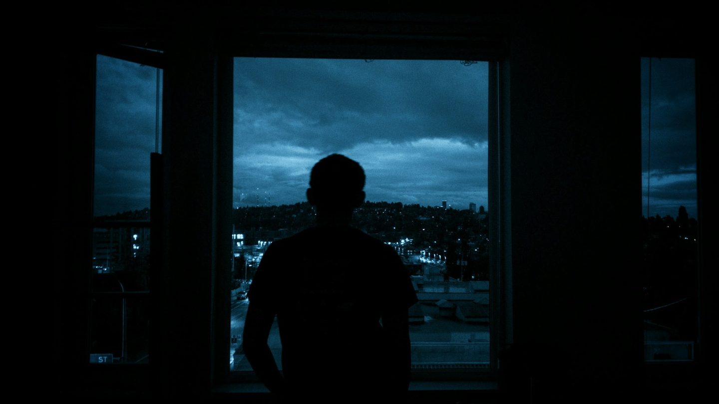 A man awake at night by a window